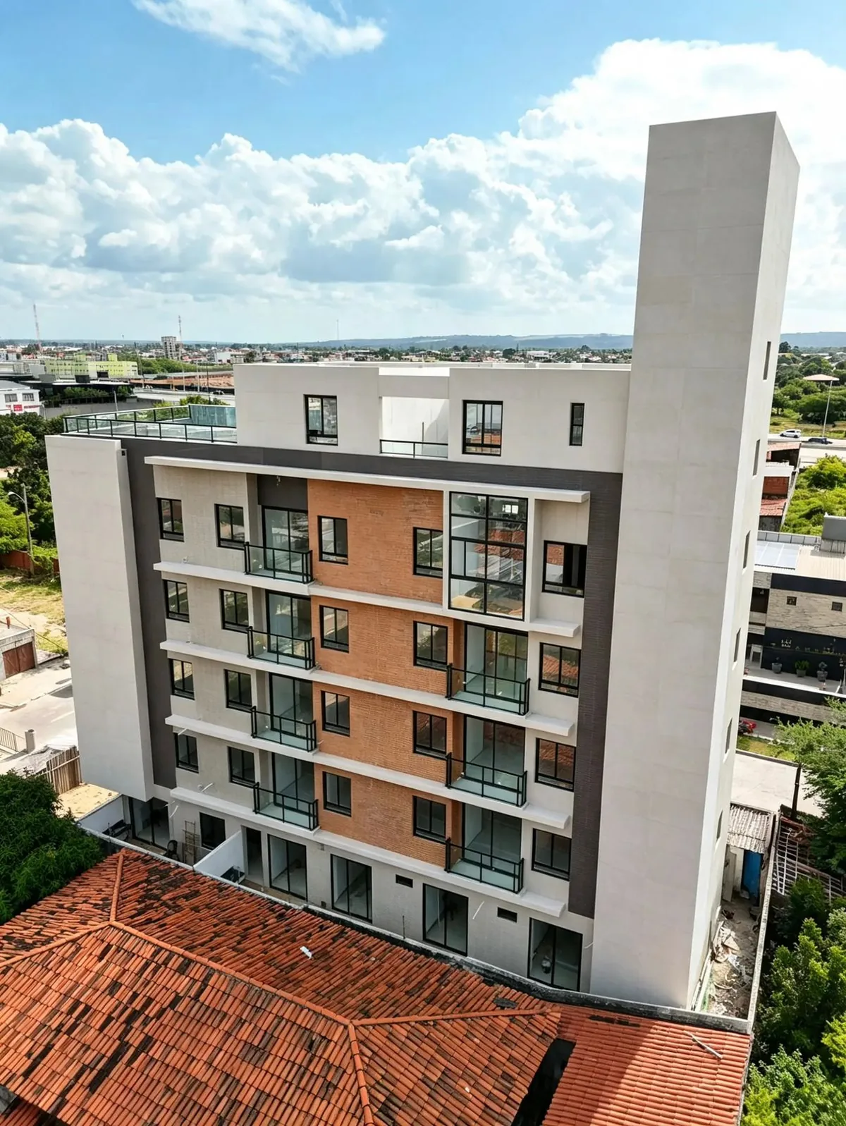 Fachada de edifício residencial com esquadrias pretas, sacadas em vidro e revestimento em tijolo